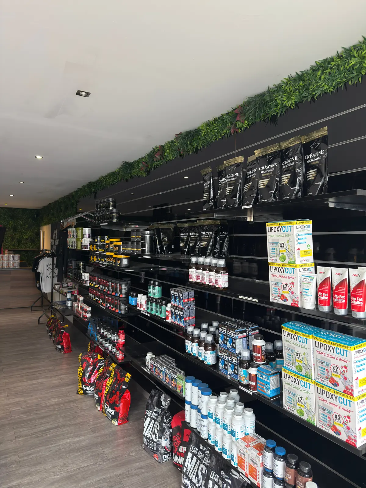 L'allée centrale de la boutique BodyStart Nutrition à Coignières, rayons de compléments alimentaires pleins